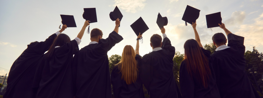 2 of 3, Graduates holding their caps in the air.